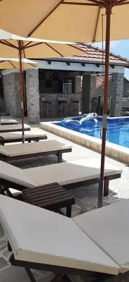 a group of tables and umbrellas next to a swimming pool at Holiday home Kristina in Krimovice