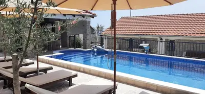 a swimming pool with an umbrella next to a building at Holiday home Kristina in Krimovice