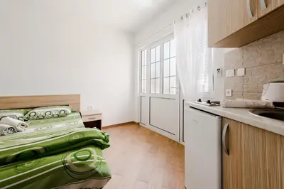 a kitchen with a sink and a green bed in it at Apartments Vukmarković in Sutomore