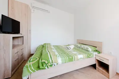 a bedroom with a bed with a tv on it at Apartments Vukmarković in Sutomore