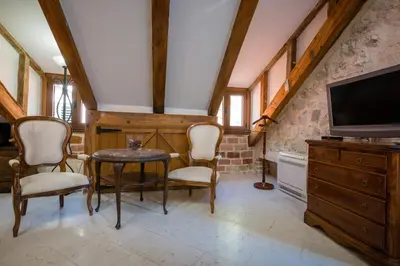 a living room with a table and chairs and a tv at Hotel Villa Duomo in Kotor