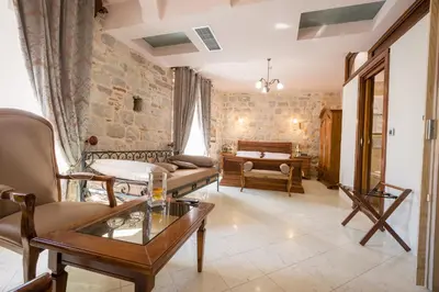 a living room with a couch and a table at Hotel Villa Duomo in Kotor