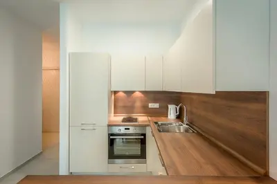 a kitchen with white cabinets and a sink at Adriatic Sunshine Apartment in Budva