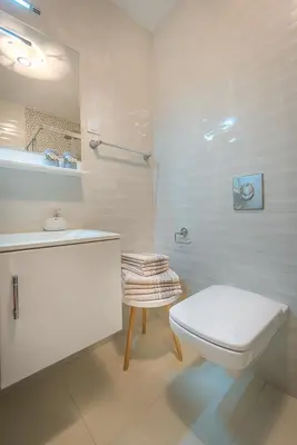 a white bathroom with a toilet and a sink at Adriatic Sunshine Apartment in Budva