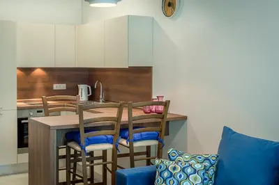 a kitchen with a table and chairs in a kitchen at Adriatic Sunshine Apartment in Budva