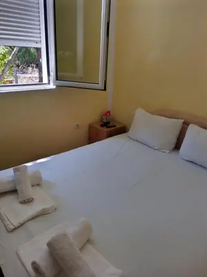 a bedroom with a white bed with towels on it at Vila Branka in Čanj