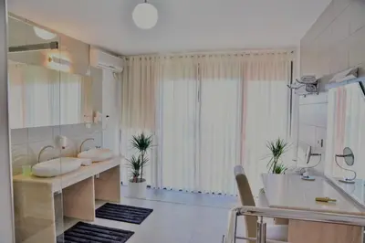 a bathroom with two sinks and a large window at Hotel Freiburg in Ulcinj