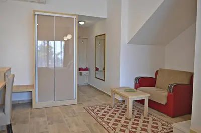 a living room with a red couch and a table at Hotel Freiburg in Ulcinj