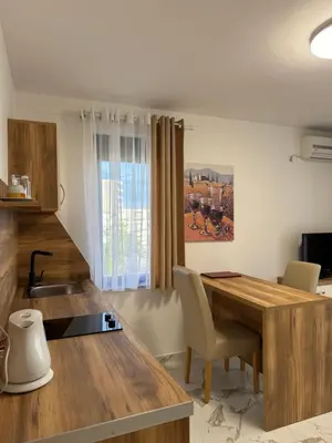 a kitchen with a wooden table and a desk at Hotel Freiburg in Ulcinj