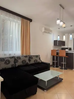 a living room with a black couch and a table at Hotel Freiburg in Ulcinj