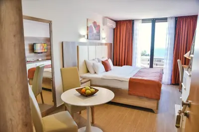 a hotel room with a bed and a table with a bowl of fruit at Hotel Freiburg in Ulcinj