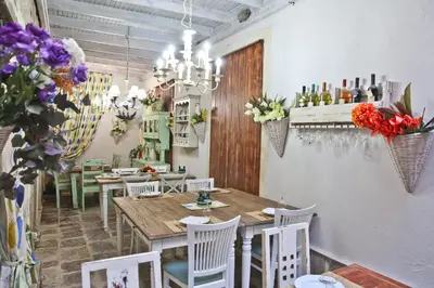 a dining room with a table and chairs and flowers at Hotel Marija in Kotor