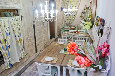 a dining room with a table and chairs and flowers at Hotel Marija in Kotor