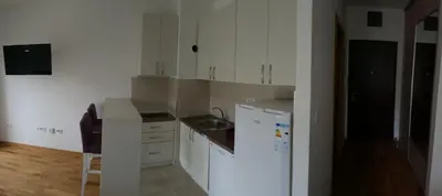 a small kitchen with white cabinets and a sink at Zebra in Podgorica