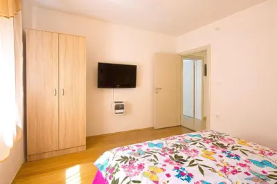 a bedroom with a bed and a flat screen tv at Apartman Aleksandra in Budva