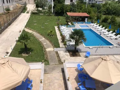 an overhead view of a swimming pool with chairs and umbrellas at Guest House Green Garden in Ulcinj