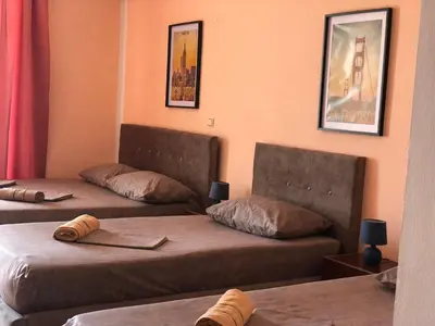 a room with two beds and two chairs in it at Guest House Green Garden in Ulcinj