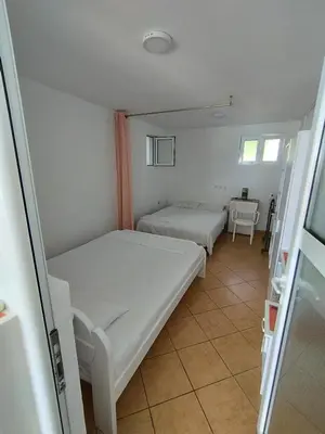 a small room with two beds and a table at Seaside Apartment Kruce in Kruče