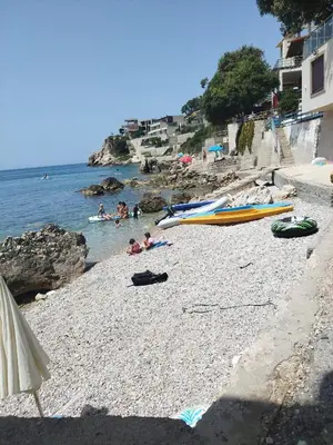 a beach with a group of people and boats on it at Seaside Apartment Kruce in Kruče