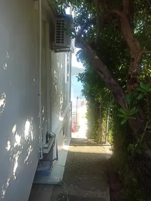 a hallway leading to a house with a tree at Seaside Apartment Kruce in Kruče