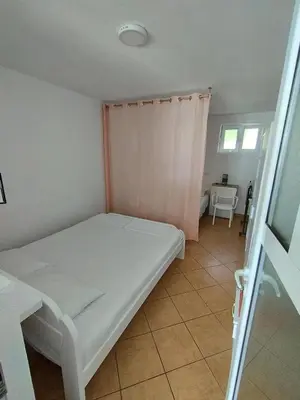 a small bedroom with a bed and a window at Seaside Apartment Kruce in Kruče