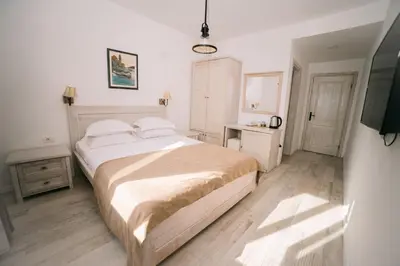 a bedroom with a large bed and a television at Hotel Pirate Old Town in Ulcinj