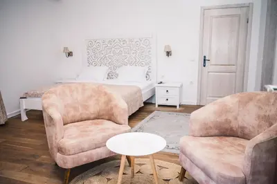 a bedroom with a bed and two chairs and a table at Hotel Pirate Old Town in Ulcinj