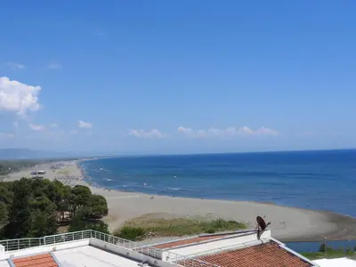 a person standing on a roof looking at a beach at Apartments Basha 1 - Long Beach in Ulcinj