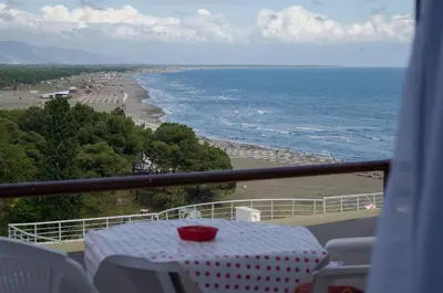 a table on a balcony with a view of the beach at Apartments Basha 1 - Long Beach in Ulcinj
