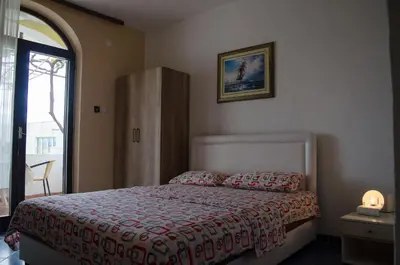 a bedroom with a bed with a red bedspread at Apartments Basha 1 - Long Beach in Ulcinj