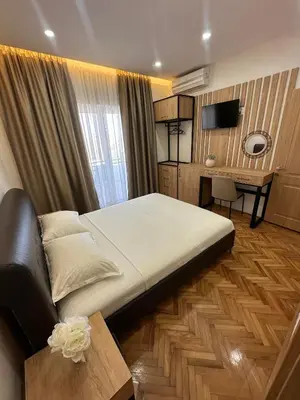 a bedroom with a large bed and a desk at Apartments Basha 1 - Long Beach in Ulcinj