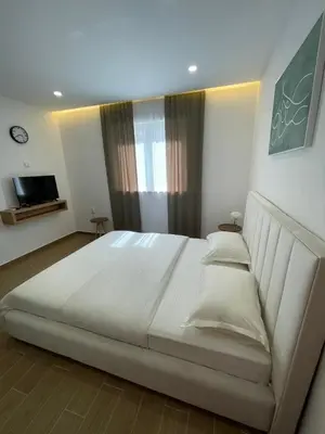 a bedroom with a large white bed in front of a window at Apartments Basha 1 - Long Beach in Ulcinj