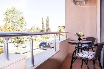 a balcony with a table and chairs and a view of a street at Apartments Rudovic in Ulcinj