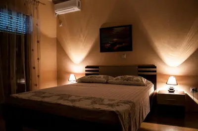 a bedroom with a bed with two lamps and a window at Apartments Rudovic in Ulcinj