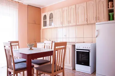 a kitchen with a table and chairs and a refrigerator at Apartments Rudovic in Ulcinj