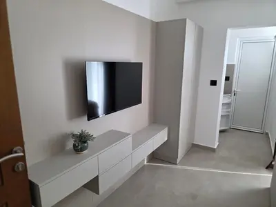 a living room with a television on a wall at Marini Casa in Ulcinj