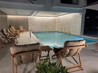 a pool with chairs and a table and a swimming pool at Marini Casa in Ulcinj