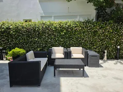a group of chairs and tables in front of a hedge at Marini Casa in Ulcinj