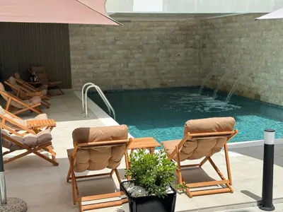 a swimming pool with two chairs and a table at Marini Casa in Ulcinj