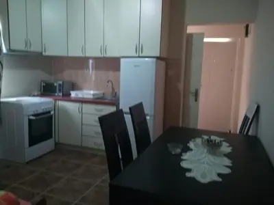 a kitchen with a black table with chairs and a white refrigerator at Apartmani Cuce in Kotor
