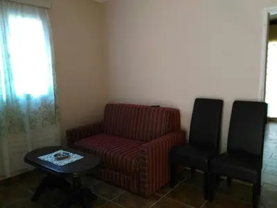 a living room with a red chair and a table at Apartmani Cuce in Kotor