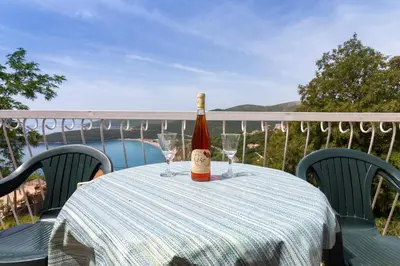 a bottle of wine sitting on a table with wine glasses at Do Re Mi Apartments in Budva