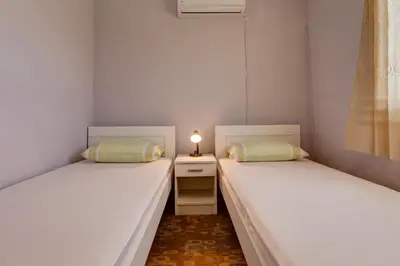 two twin beds in a small room with a lamp at Do Re Mi Apartments in Budva