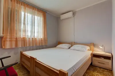 a bedroom with a large bed and a window at Do Re Mi Apartments in Budva