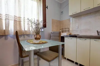 a kitchen with a table and chairs in a kitchen at Do Re Mi Apartments in Budva