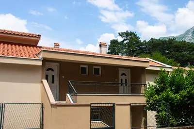 a house with a balcony with a fence at Veron Apartments in Kotor