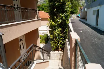 an empty street next to a building with balconies at Veron Apartments in Kotor