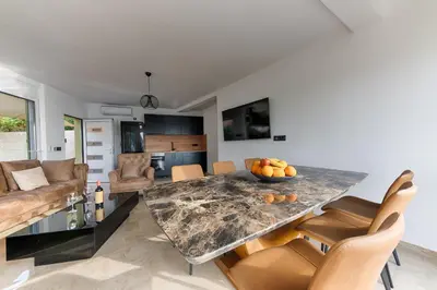 a kitchen and living room with a marble table and chairs at Resort Stikovic in Dobra Voda