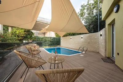 a patio with a table and chairs and a swimming pool at Resort Stikovic in Dobra Voda