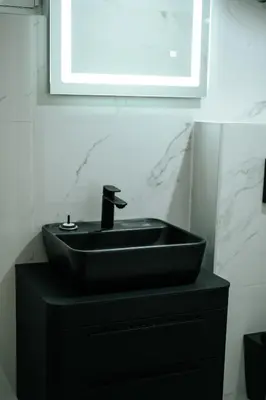 a bathroom with a black sink and a mirror at Resort Stikovic in Dobra Voda